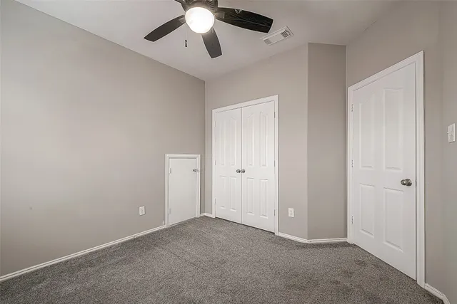 an empty room with a window and a fan