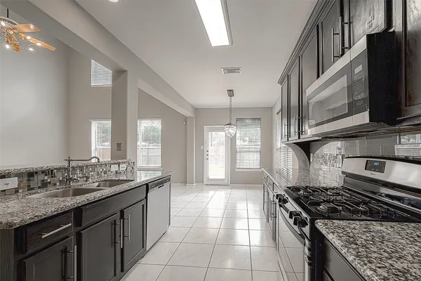 a kitchen with stainless steel appliances granite countertop a sink stove and cabinets