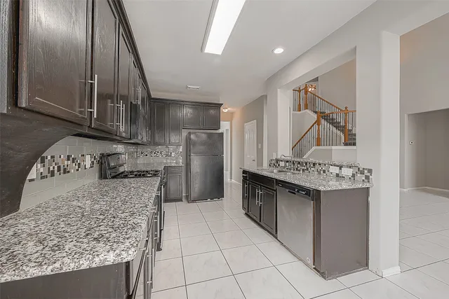 a kitchen with stainless steel appliances granite countertop a sink stove and refrigerator