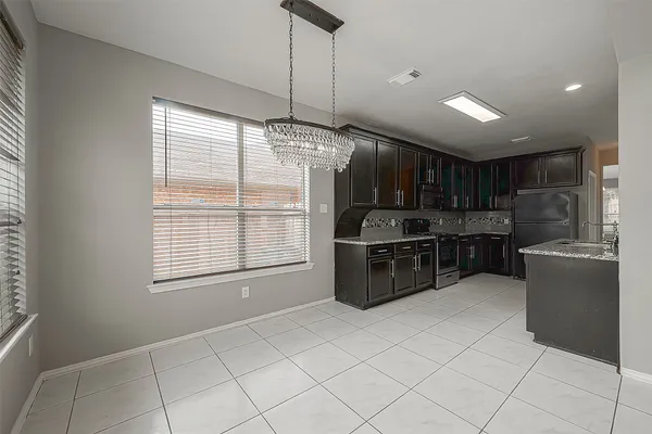 a kitchen with stainless steel appliances kitchen island granite countertop a refrigerator and a sink