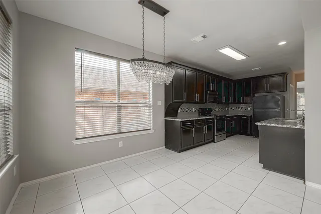 a kitchen with stainless steel appliances kitchen island granite countertop a refrigerator and a sink