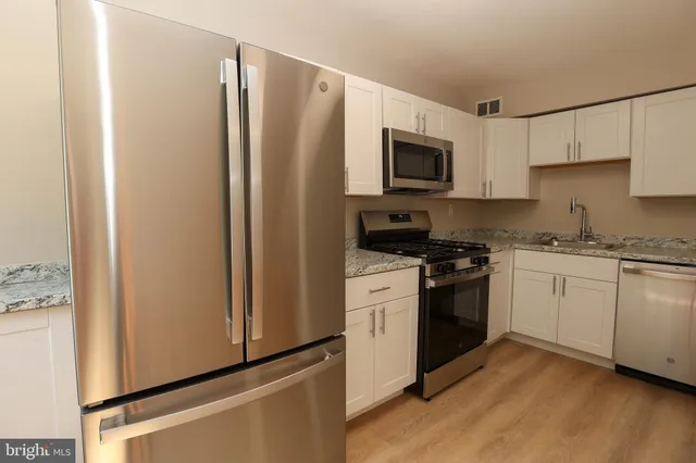 a kitchen with a refrigerator stove and white cabinets