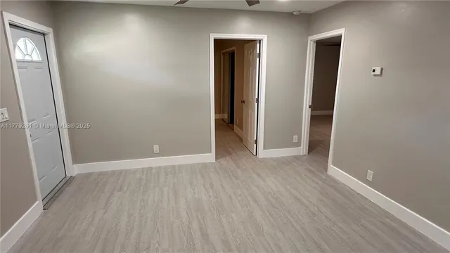 an empty room with wooden floor and closet