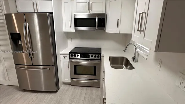 a kitchen with a refrigerator sink and microwave