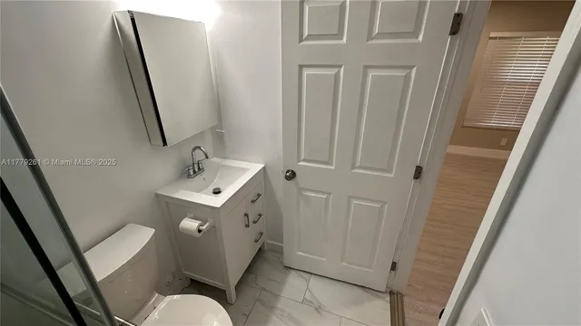 a bathroom with a sink toilet and mirror