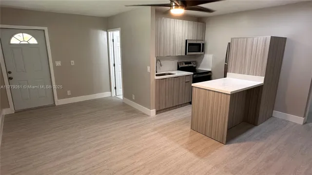 a kitchen with a refrigerator a sink and a microwave