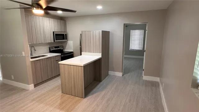 a kitchen with a sink refrigerator and microwave