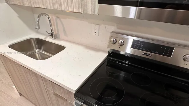 a close view of a sink and a stove in a kitchen