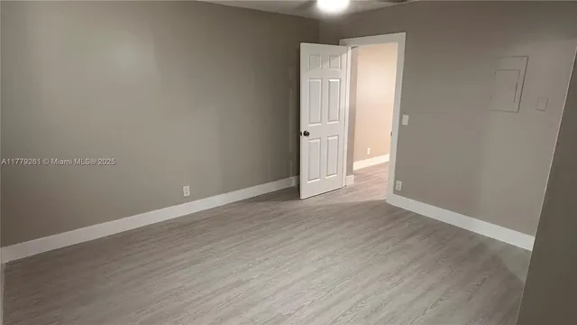 a view of an empty room with wooden floor