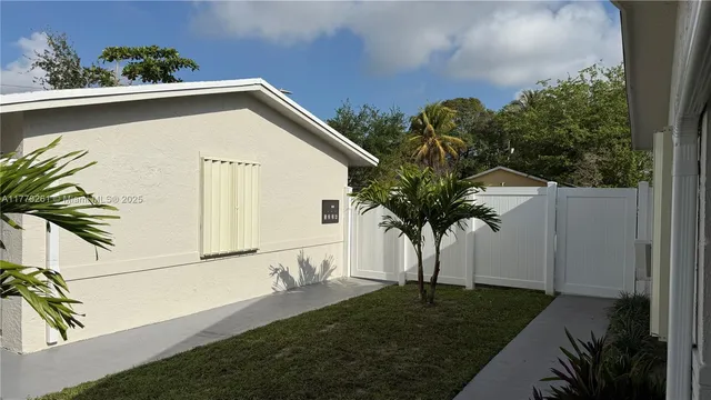 a view of a house with a yard and potted plants