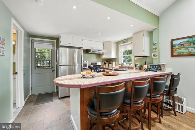 a kitchen with a table chairs sink and cabinets