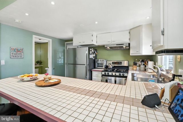 a kitchen with stainless steel appliances kitchen island granite countertop a sink and cabinets