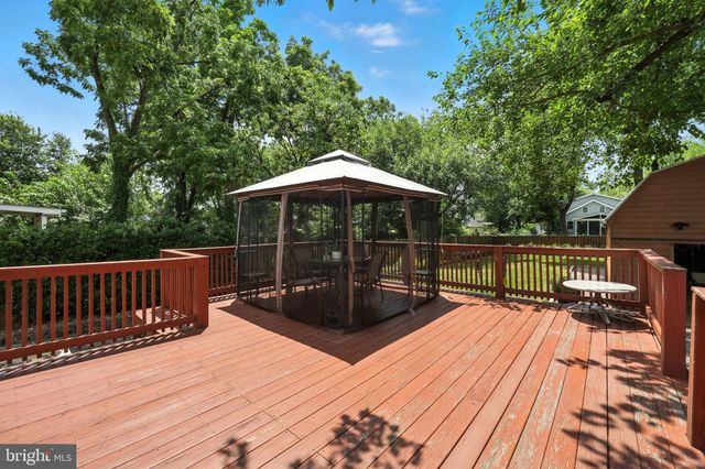 a view of a roof deck with table and chairs under an umbrella with wooden floor