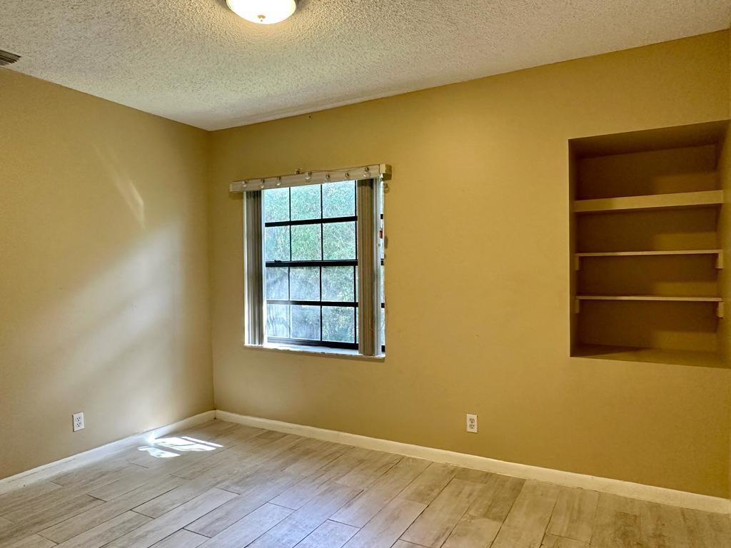 5438 Verona Drive, Unit 812 Boynton Beach, FL 33437 - Photo 17 of 35 a view of an empty room with wooden floor and a window
