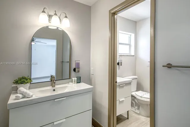 a bathroom with a toilet a sink and mirror