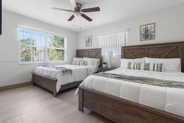 a bedroom with two beds and a large window