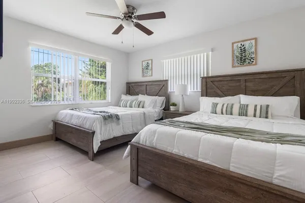 a bedroom with two beds and a large window