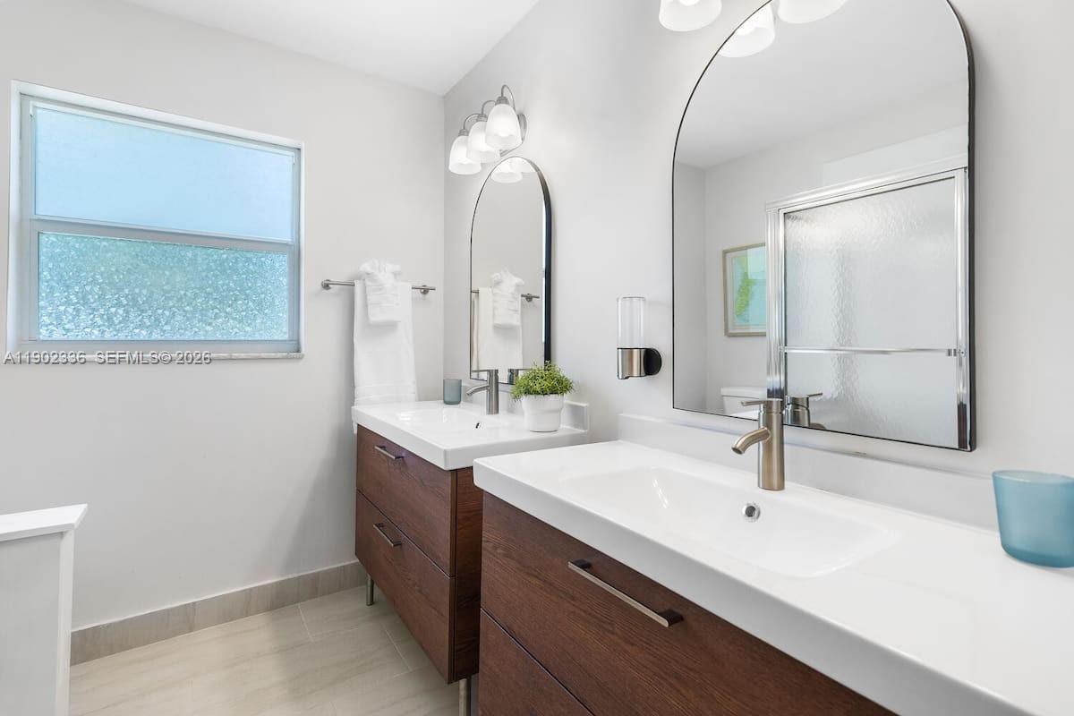 1500 Northwest 45th Street Pompano Beach, FL 33064 - Photo 17 of 23 a bathroom with a double vanity sink and a mirror