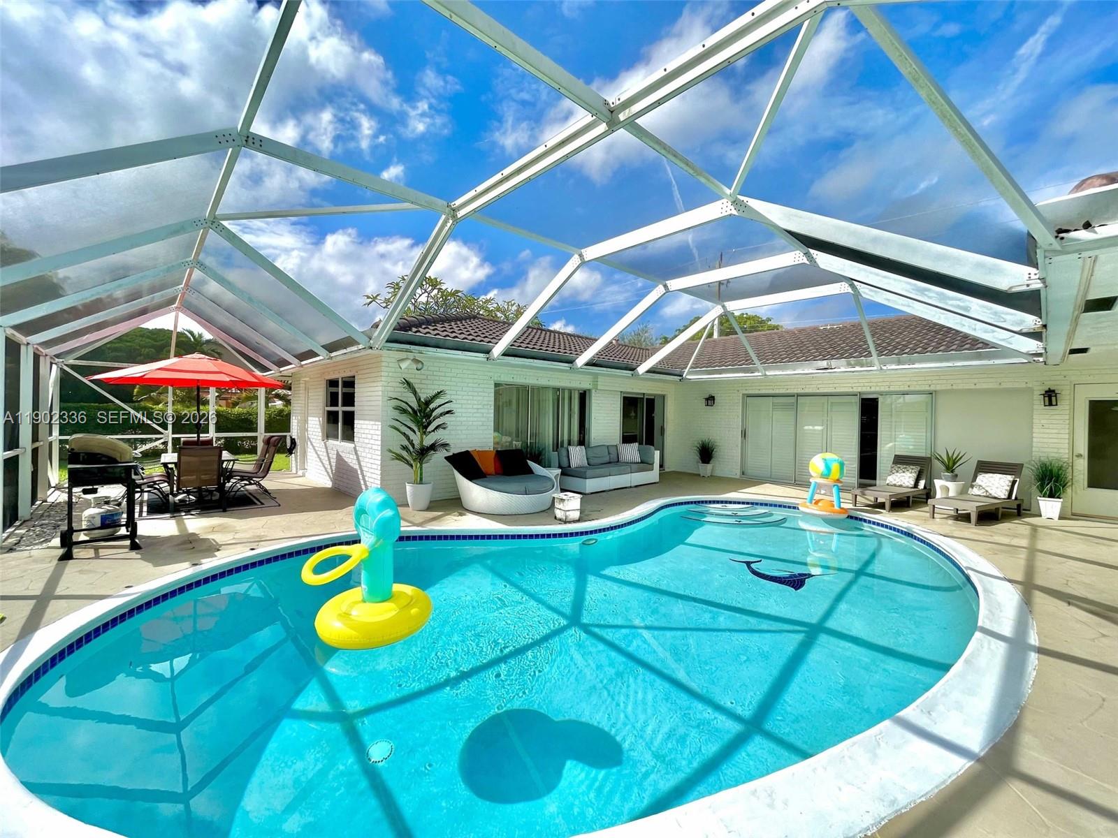 1500 Northwest 45th Street Pompano Beach, FL 33064 - Photo 3 of 23 a view of a swimming pool with chairs and tables