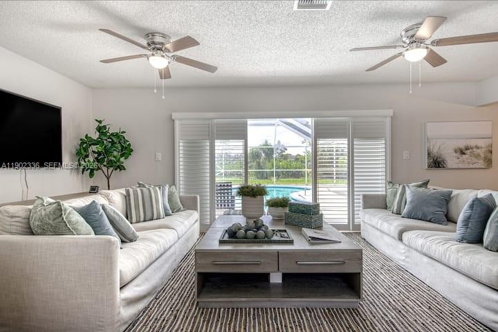 1500 Northwest 45th Street Pompano Beach, FL 33064 - Photo 4 of 23 a living room with furniture a large window and a flat screen tv