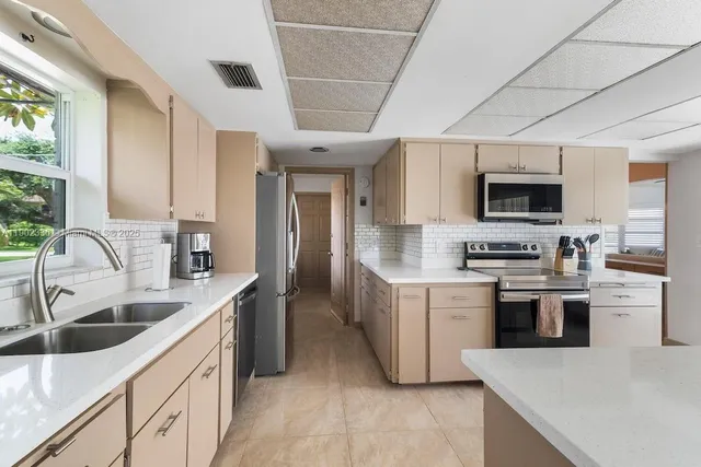 a kitchen with stainless steel appliances granite countertop a sink stove and refrigerator