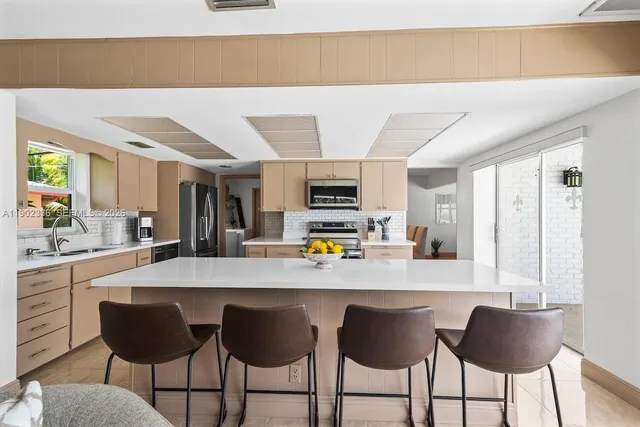 a kitchen with stainless steel appliances kitchen island granite countertop a table and chairs