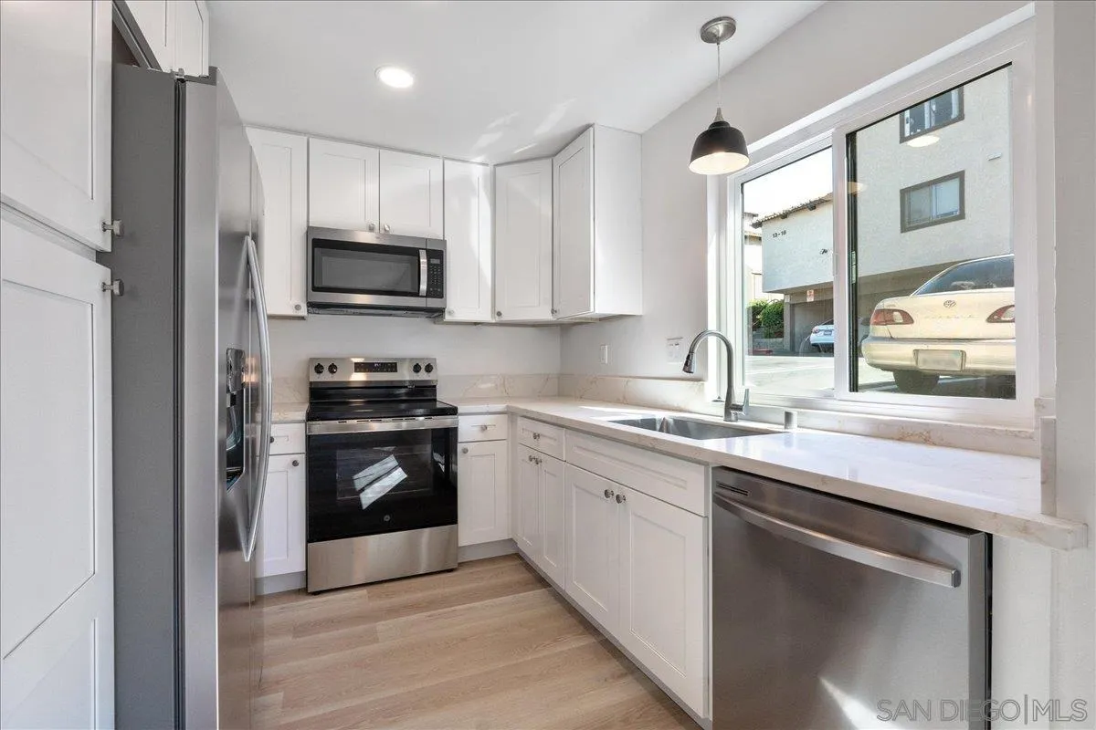 955 Postal Way, Unit 29 Vista, CA 92083 - Photo 2 of 32 a kitchen with stainless steel appliances granite countertop a stove a sink and a refrigerator