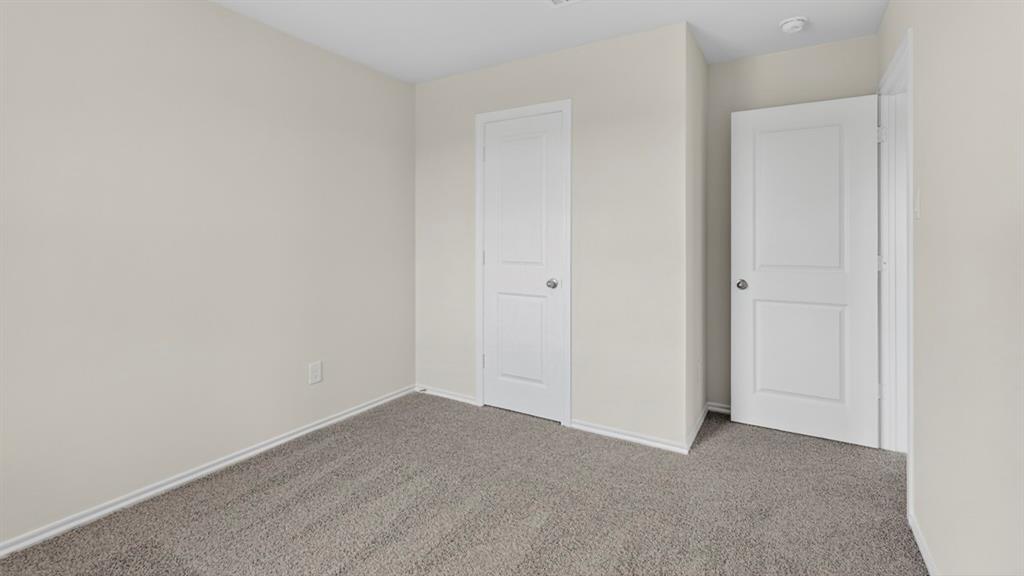 1683 Mantle Road Crandall, TX 75114 - Photo 29 of 31 Neutral-toned interior room featuring light gray carpeting and two white paneled doors with brushed nickel hardware