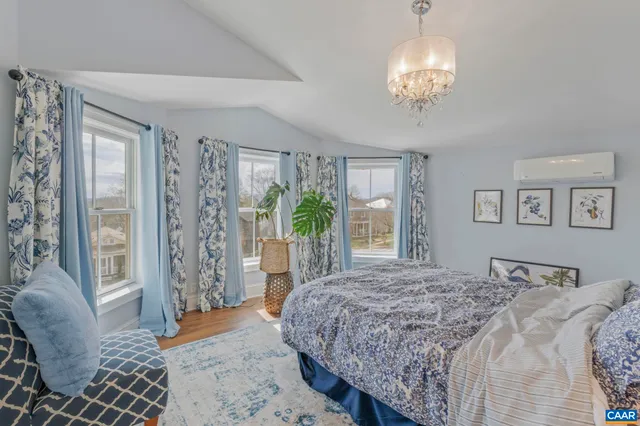 a living room with furniture a wooden floor and next to a window