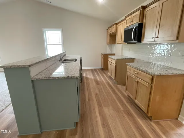 a kitchen with stainless steel appliances granite countertop a sink stove and microwave