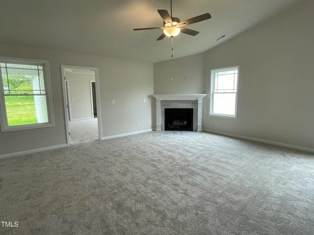 an empty room with a fireplace and a window