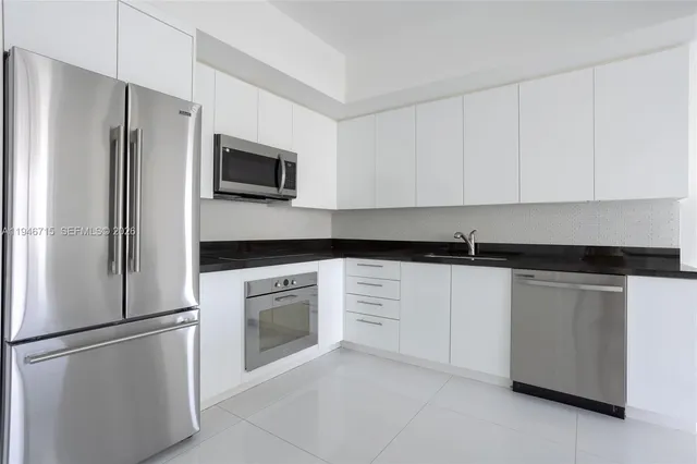 a kitchen with cabinets stainless steel appliances and a sink
