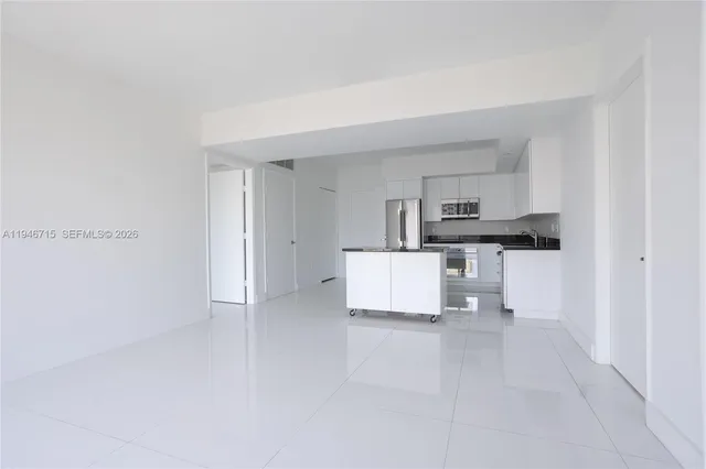 a kitchen with granite countertop white cabinets and stainless steel appliances