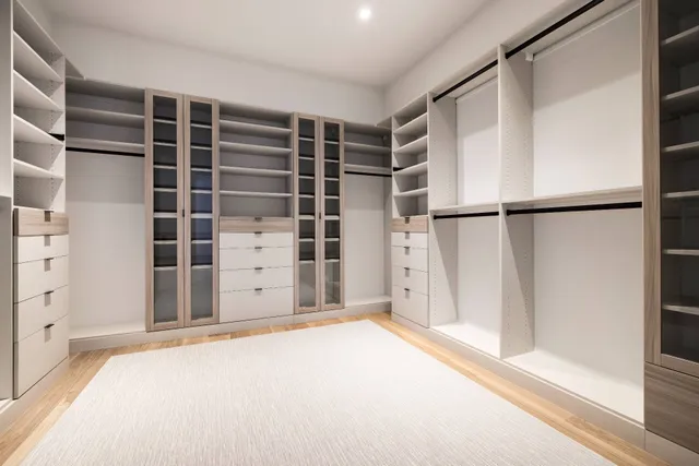 a view of an empty room with cabinet and a window