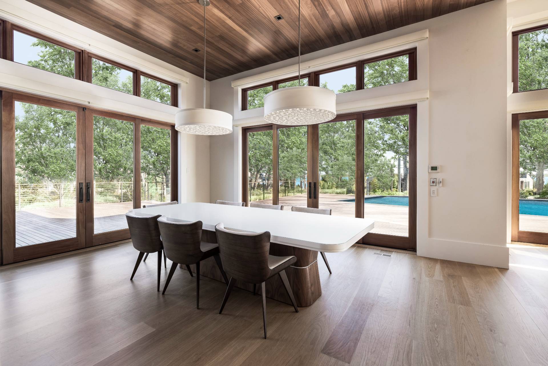 26 Mashomuck Drive Sag Harbor, NY 11963 - Photo 4 of 25 a dining room with wooden floor a chandelier a glass table and chairs