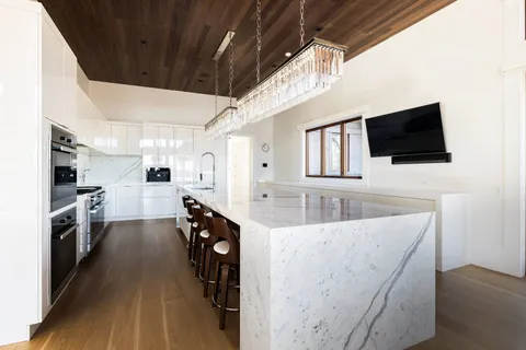 a living room with stainless steel appliances furniture and a flat screen tv