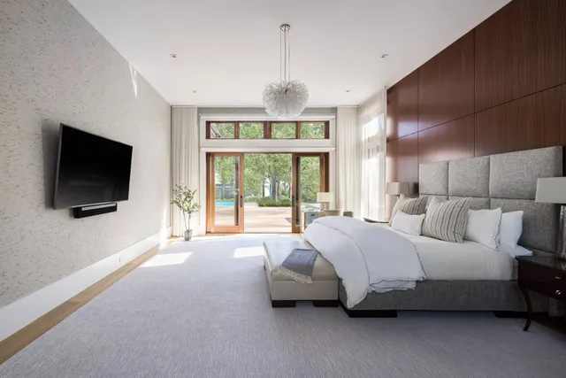 a spacious bedroom with a bed and a flat screen tv