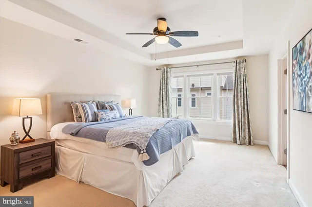 a spacious bedroom with a bed and a chandelier