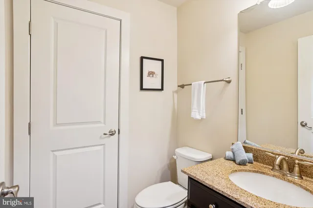 a bathroom with a granite countertop toilet sink and mirror