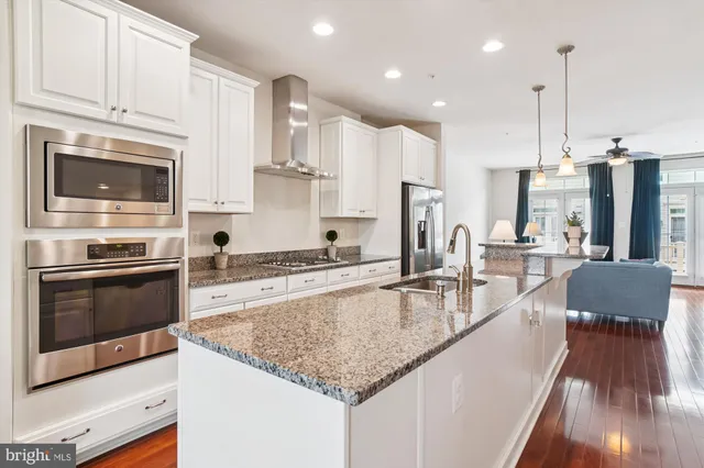 a kitchen with stainless steel appliances granite countertop a stove top oven a sink and a granite counter tops