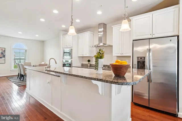 a kitchen with stainless steel appliances granite countertop a refrigerator a sink and a stove