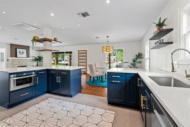 a kitchen with stainless steel appliances granite countertop a sink and a refrigerator