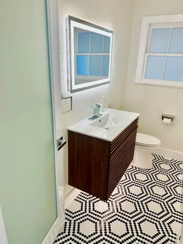 a bathroom with a sink a toilet and mirror