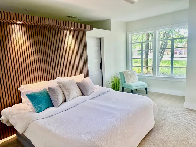 a bedroom with a bed and a large window