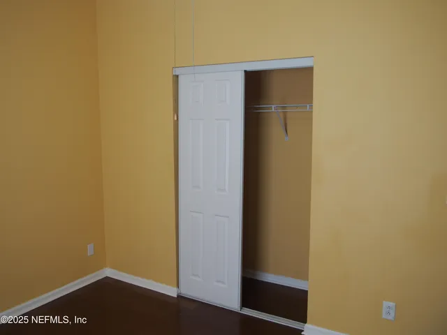 a view of a small space with wooden floor and a window