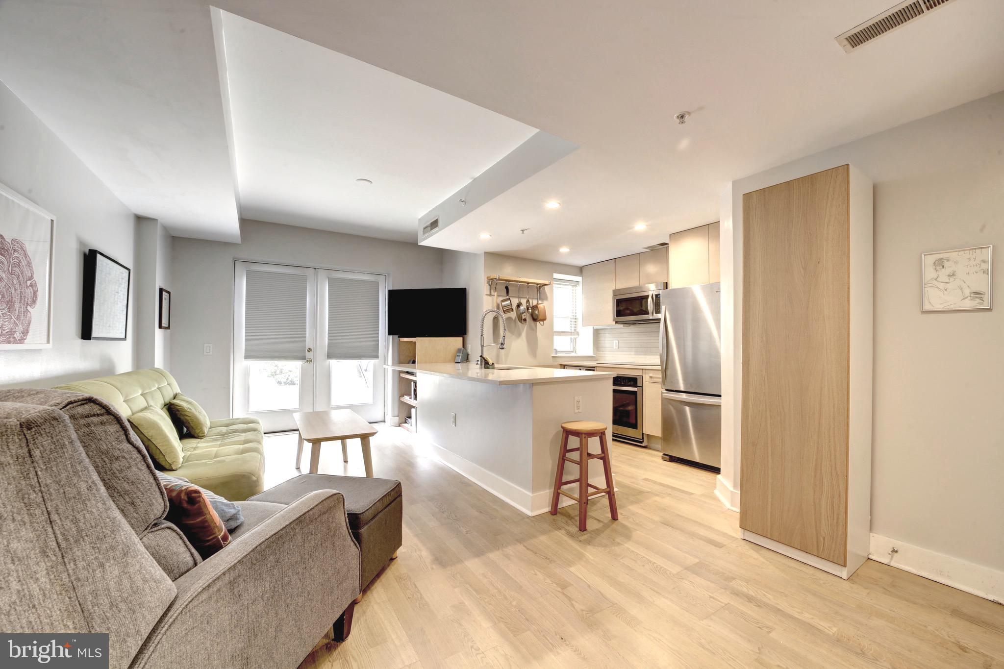 a living room with furniture and kitchen view