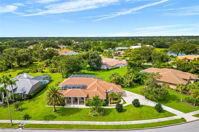 an aerial view of residential houses with outdoor space and trees