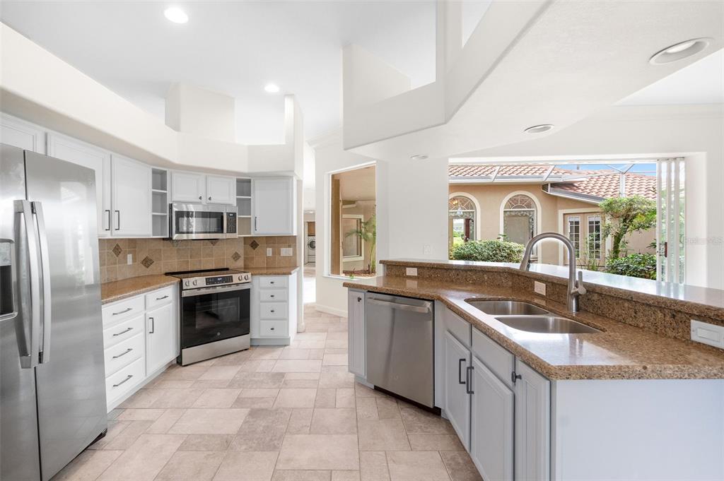 8356 Mareva Lane Sarasota, FL 34241 - Photo 15 of 44 a kitchen with stainless steel appliances granite countertop a sink stove oven and refrigerator