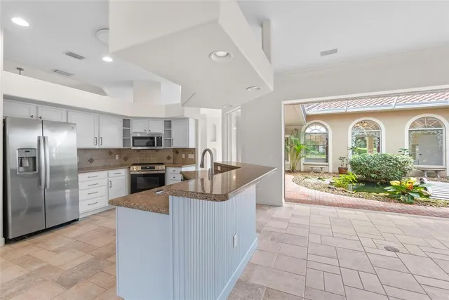 a large kitchen with a large counter top and stainless steel appliances