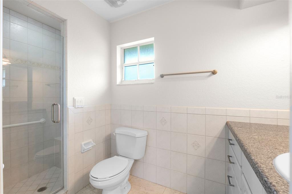 8356 Mareva Lane Sarasota, FL 34241 - Photo 39 of 44 a bathroom with a granite countertop toilet a sink and shower